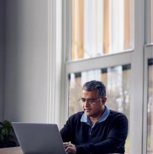 man sitting at the kitchen table with his laptop